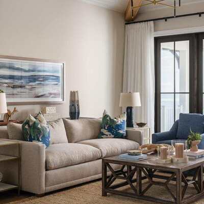 Small coastal living room with light-colored furniture, a compact sofa, and uncluttered decor.